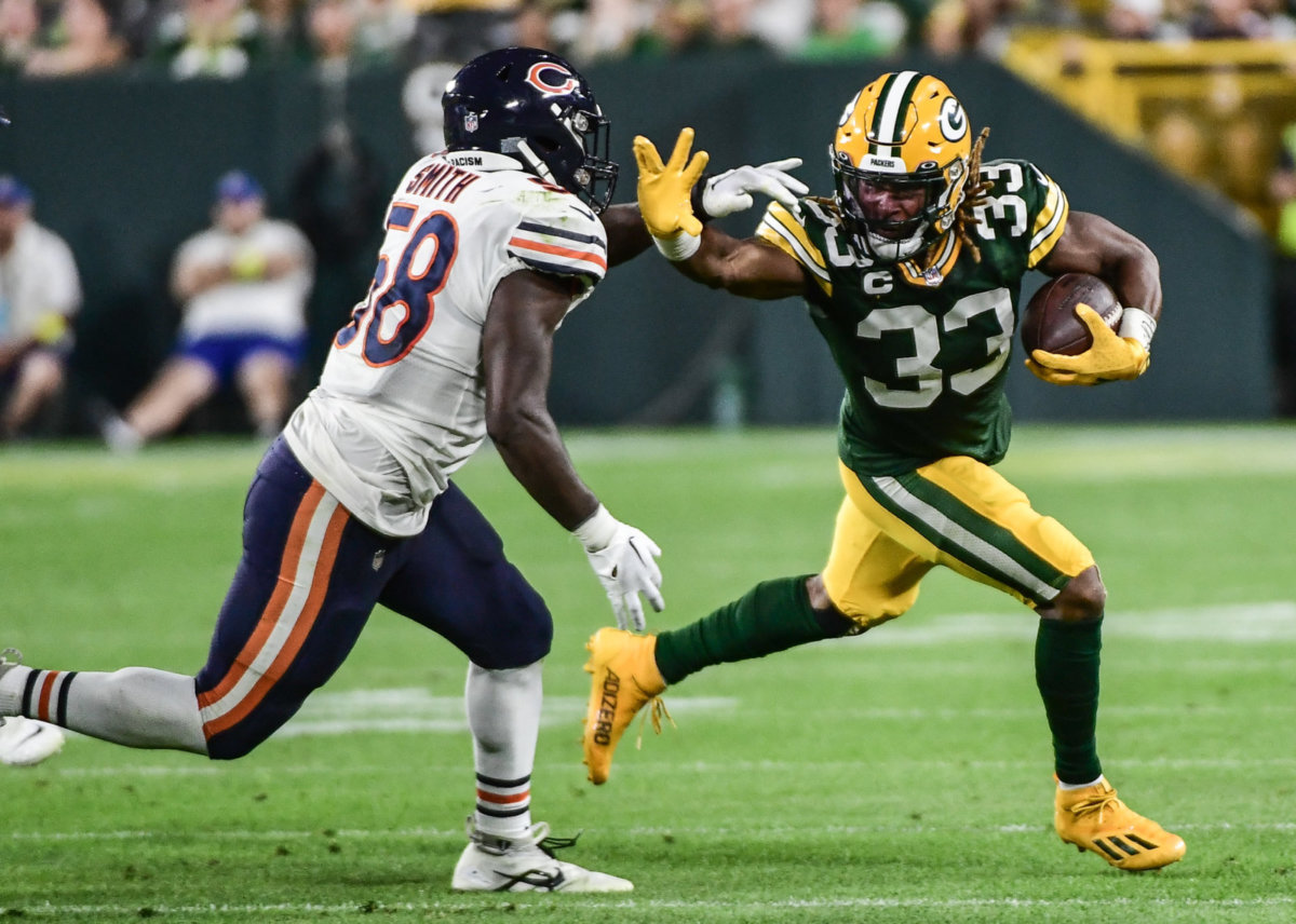 Sep 18, 2022; Green Bay, Wisconsin, USA; Green Bay Packers running back Aaron Jones (33) tries to break a tackle by Chicago Bears linebacker Roquan Smith (58) in the second quarter at Lambeau Field. Benny Sieu-USA TODAY Sports
